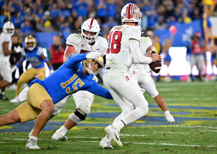 Oct 29, 2022; Pasadena, California, USA; Stanford Cardinal quarterback Tanner McKee (18) is pressured by UCLA Bruins linebacker Laiatu Latu (15) in the first half at the Rose Bowl. Mandatory Credit: Jayne Kamin-Oncea-USA TODAY Sports